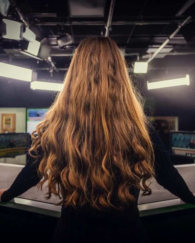 Lisah Silfwer bakifrån vid nyhetsdesken med utsläppt hår.